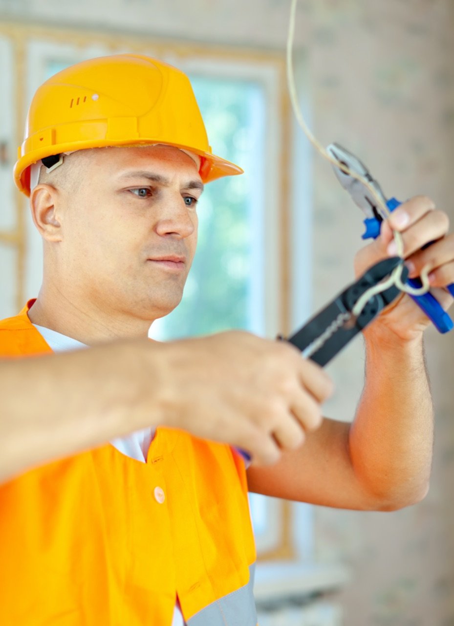 Eletricista instalando fiação elétrica em uma casa nova